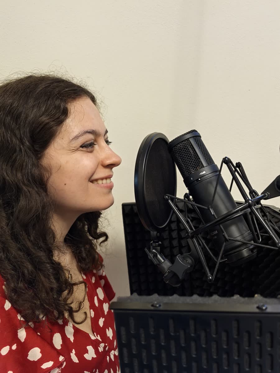 Alessia Guida sorride davanti a un microfono da studio